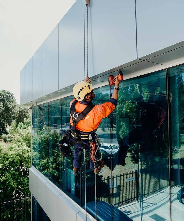 Technician performing after-sales maintenance on a glass facade